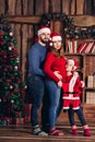 Husband, pregnant wife and daughter hold a Christmas costume for the baby.