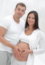 Husband and pregnant wife with folded hands in the shape of a heart on his tummy Royalty Free Stock Photo