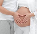 Husband and pregnant wife with folded hands in the shape of a heart on his tummy Royalty Free Stock Photo