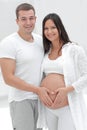 Husband and pregnant wife with folded hands in the shape of a heart on his tummy Royalty Free Stock Photo