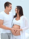 Husband and pregnant wife with folded hands in the shape of a heart on his tummy Royalty Free Stock Photo