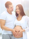 Husband and pregnant wife with folded hands in the shape of a heart on his tummy Royalty Free Stock Photo