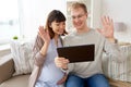 Husband and pregnant wife with tablet pc at home Royalty Free Stock Photo