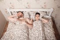 Husband snores in a dream, wife closes ears.