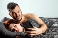 Husband spies on his wife`s phone while she sleeps. The concept of distrust, betrayal, jealousy, relationships, problems Royalty Free Stock Photo