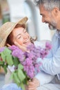 Husband surprises his wife with a bouquet of lilacs