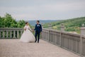 Husband and wife on the background of the river and mountains stroll through the observation point, from where they