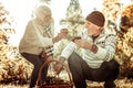 Husband and wife comparing mushrooms in the forest.