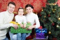 Husband, wife and daugther hold gift and smile Royalty Free Stock Photo