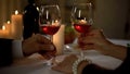 Husband and wife hands holding red wine glasses, tender feelings, toasting Royalty Free Stock Photo