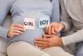 Husband and wife holding GIRL and BOY cards near pregnant belly Royalty Free Stock Photo