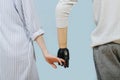 Husband and wife holding hands. Living hand and bionic prosthetic hand