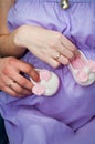 The husband and wife, mom and dad hold hands with booties on the belly.pregnancy Royalty Free Stock Photo