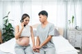 Husband wife sat on bed, pregnant wife, sit answer phone call from doctor, tense expression, husband pulled wife into embrace, two Royalty Free Stock Photo