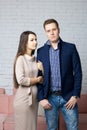 Husband and wife on the set in the studio. The wife with tenderness holds her husband`s arm. A husband with a pleased look is