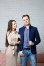 Husband and wife on the set in the studio. The wife with tenderness holds her husband`s arm. A husband with a pleased look is