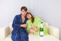 Husband and wife sit on sofa and drink fizz Royalty Free Stock Photo