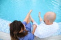 Husband and wife sitting barefoot near swiming pool. Royalty Free Stock Photo