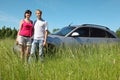 Husband, wife stand near car