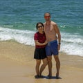 Husband and wife standing in the sand of Medano Beach with the Sea of Cortez in the background in Cabo San Lucas. Royalty Free Stock Photo