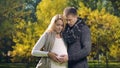 Husband and wife stroking pregnant belly, waiting for newborn baby, parenting
