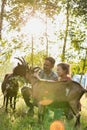 Two farmers, husband and wife tending to their goat on their farm