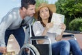 Husband and woman in wheelchair looking at map Royalty Free Stock Photo