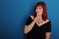 Attractive woman in black dress, red hair making gesture silence Royalty Free Stock Photo