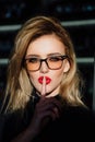 Hush. Woman in glasses ask for silence or secrecy with finger on red lips. shh hand gesture. Royalty Free Stock Photo