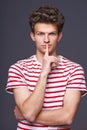 Hush. Young serious sullen man with finger on lips Royalty Free Stock Photo