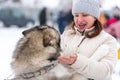 Husky dog hugs with adult woman. Winter outdoor walking - Reshetiha, Russia - 02.02.2019