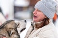 Husky dog hugs with adult woman. Winter outdoor walking - Reshetiha, Russia - 02.02.2019