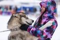 Husky dog hugs with a beautiful girl. Winter outdoor walking - Reshetiha, Russia - 02.02.2019