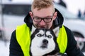 Husky dog hugs with young guy. Winter outdoor walking - Reshetiha, Russia - 02.02.2019