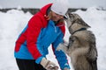 Husky dog playing with girl. Winter outdoor walking. Happy woman with pets. - Reshetiha, Russia - 02.02.2019 Royalty Free Stock Photo