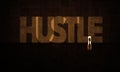 HUSTLE Written in A Grungy Wall On Big Concrete dark Room With A Businessman Hustler Entering a Light Door. Royalty Free Stock Photo