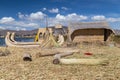 Hut and canoe boat at Uros floating island and village on Lake Titicaca near Puno, Peru Royalty Free Stock Photo