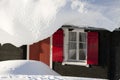 Hut with red shutters in deep snow