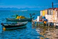 Hut by the seaside. Sunlit small blue, white and yellow Mediterranean fishing boats, with sparkling turquoise sea and pale blue Royalty Free Stock Photo