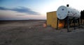 A hut and a water tank in the middle of the desert in Saudi Arabia at sunset Royalty Free Stock Photo