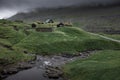 Huts with a grass roof and waterfall in Saksun village on Streymoy Island, Faroe Islands