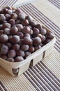 Huzelnuts in a wicker basket on a table.