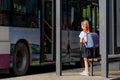 Huzhou, China 22 June 2021: Happy caucasian girl back to school in uniform and red tie at pioneer. Kid waiting public