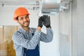 hvac indian worker install ducted pipe system for ventilation and air conditioning. copy space Royalty Free Stock Photo