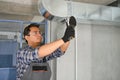 hvac indian worker install ducted pipe system for ventilation and air conditioning. copy space Royalty Free Stock Photo