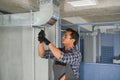 hvac indian worker install ducted pipe system for ventilation and air conditioning. copy space Royalty Free Stock Photo