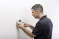 HVAC Repairman Adjusting Thermostat