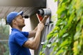 Hvac service worker doing maintenance and cleaning of central gas heating boiler flue chimney on house exterior Royalty Free Stock Photo