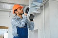 hvac services - indian worker install ducted pipe system for ventilation and air conditioning in house Royalty Free Stock Photo