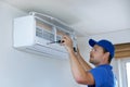 hvac services - technician installing air conditioner on the wall